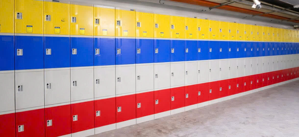 Góc nhìn nghiêng dãy tủ locker ABS N4 phối màu xanh vàng trắng đỏ tại khu vực lưu trữ.